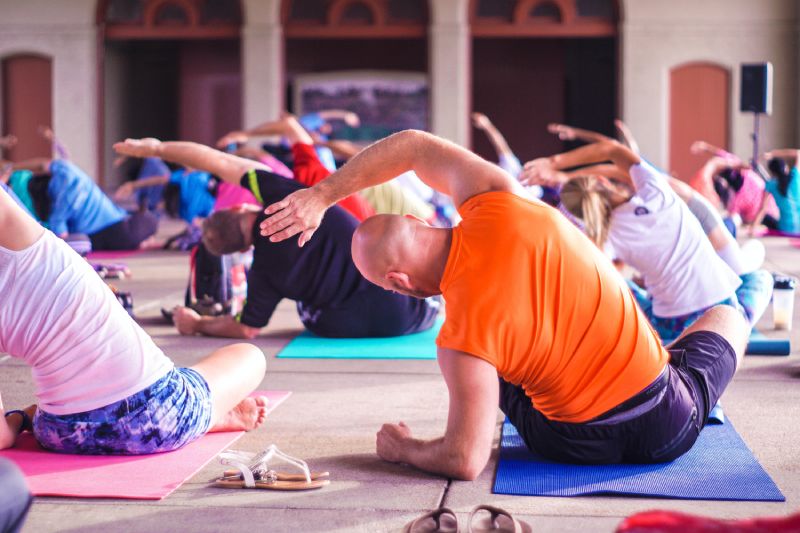 Group of people doing yoga stretches.